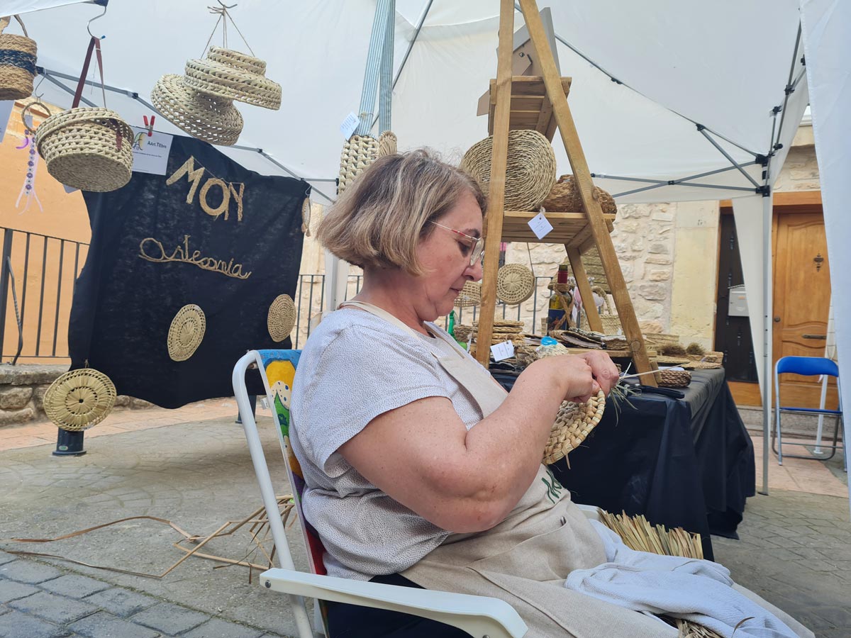 Parada Mon artesanía Senyora treballant amb la pauma.
