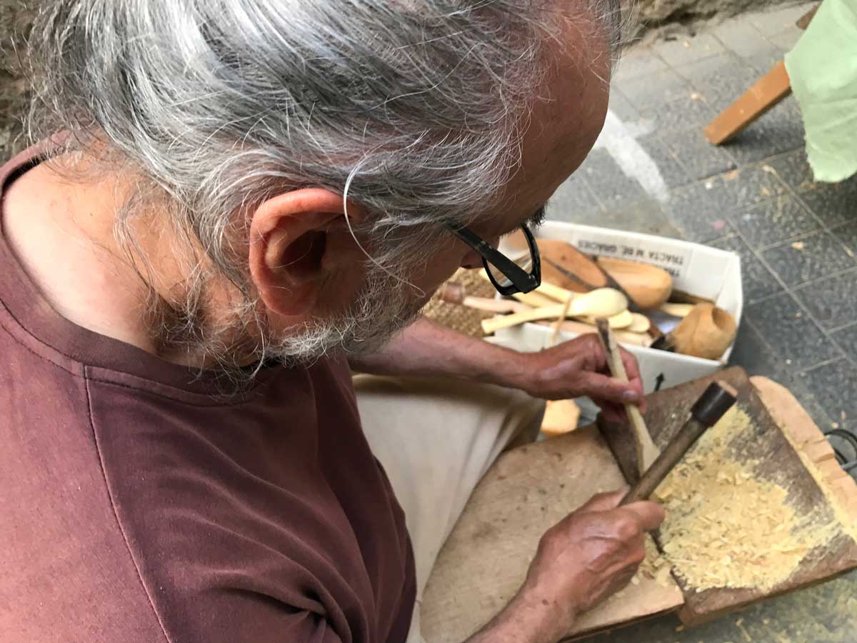 Carpintero Fuster tallant fusta per donar-li forma de cullera