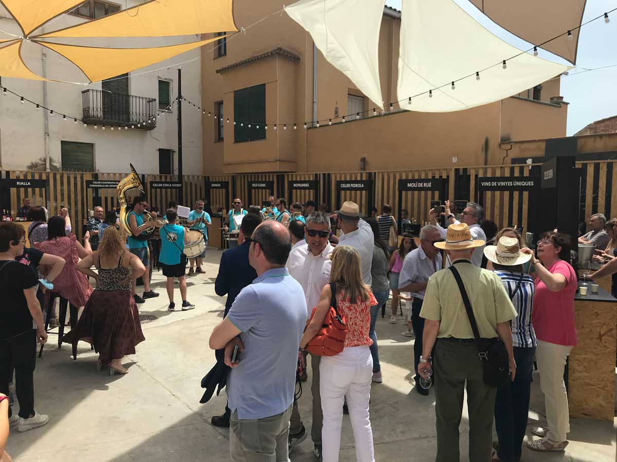 Espacio tastavin's Espai amb carpes on hi ha una xaranga i persones escoltant-los.