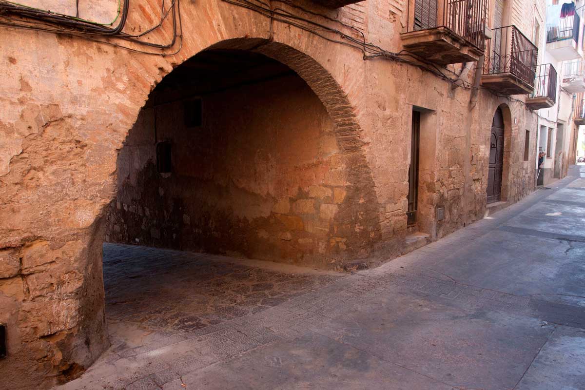 Carrer d'Ascó on hi ha una arcada de pedra