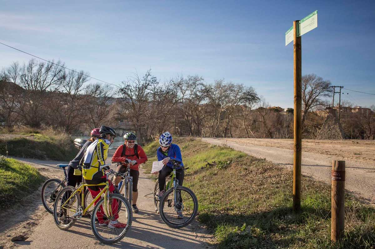 Fotografia on hi ha nois i noies amb bicicletes BTT mirant un mapa