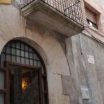 Porta de fusta amb finestres opaques.