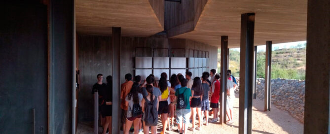 Adolescents visitant el Memorial de les Camposines un dia d'estiu.