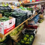 Fotografia de l'interior de la botiga. Al primer pla es veuen verdures exposades i més al fons, diferents productes com aigua...