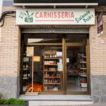 Façana de la Carnisseria M. Carme, on es veuen diferents productes exposats a l'aparador.