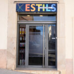 Part exterior de la perruqueria Estils amb el logotip retolat dalt de la porta.